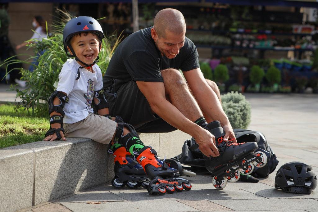 dad putting rollerblade inline skates in his feet with his son