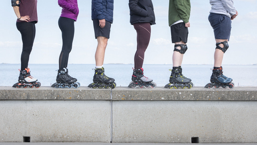 6 people line up with rollerblade inline skates in their feet